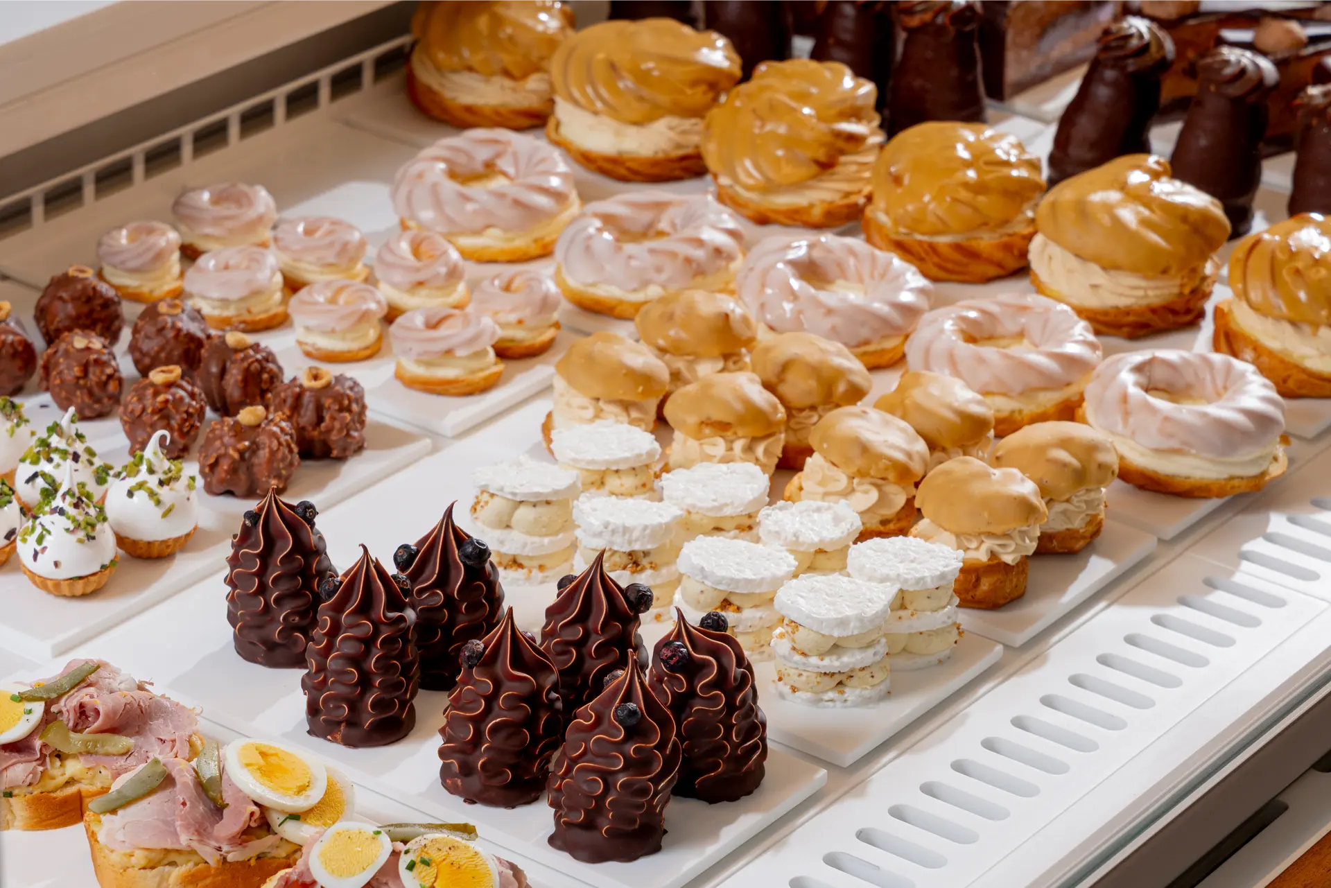 Selection of pastries and desserts in the Myšák pastry shop display case.